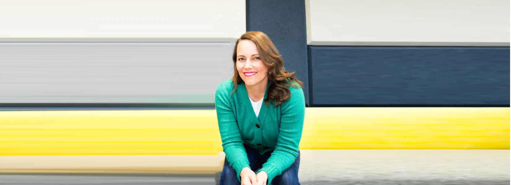 A photo of Robin sitting, smiling and welcoming you to Becoming: Coaching and Counseling.